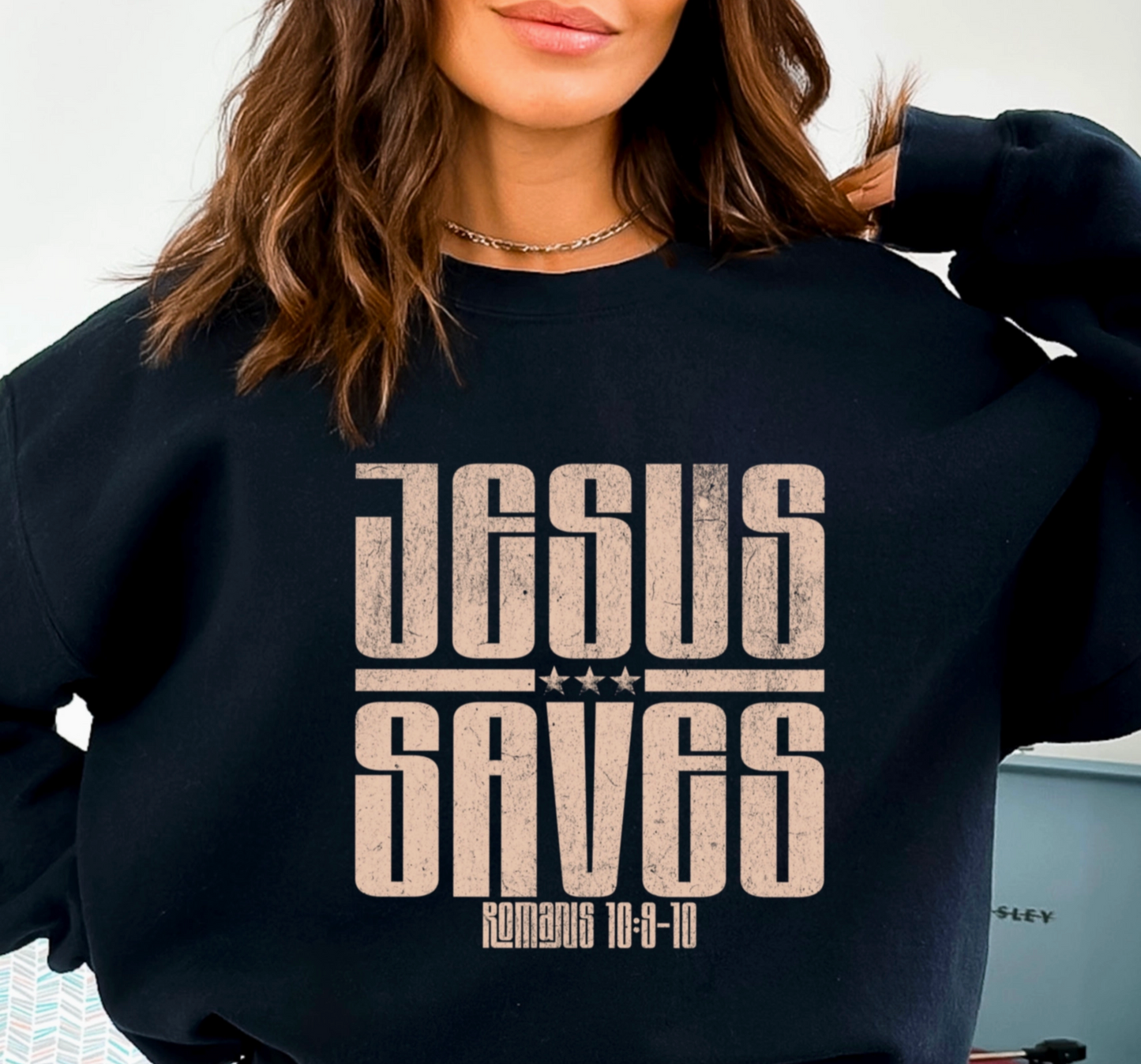 Person wearing a black sweatshirt with 'Jesus Saves' text