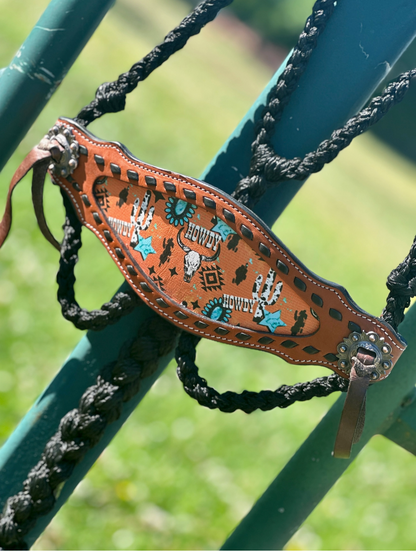 Decorative leather bridle strap with intricate designs on a green metal background