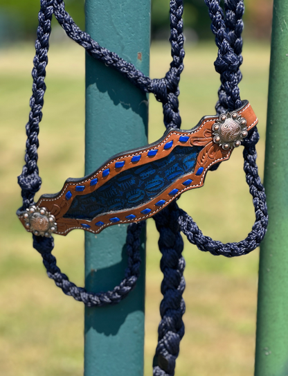 Decorative horse bridle bit with blue stones on a green metal background