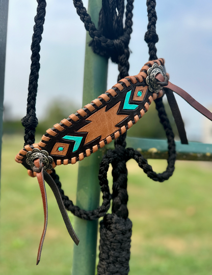 Decorative archery bow nock with turquoise accents on a blurred outdoor background
