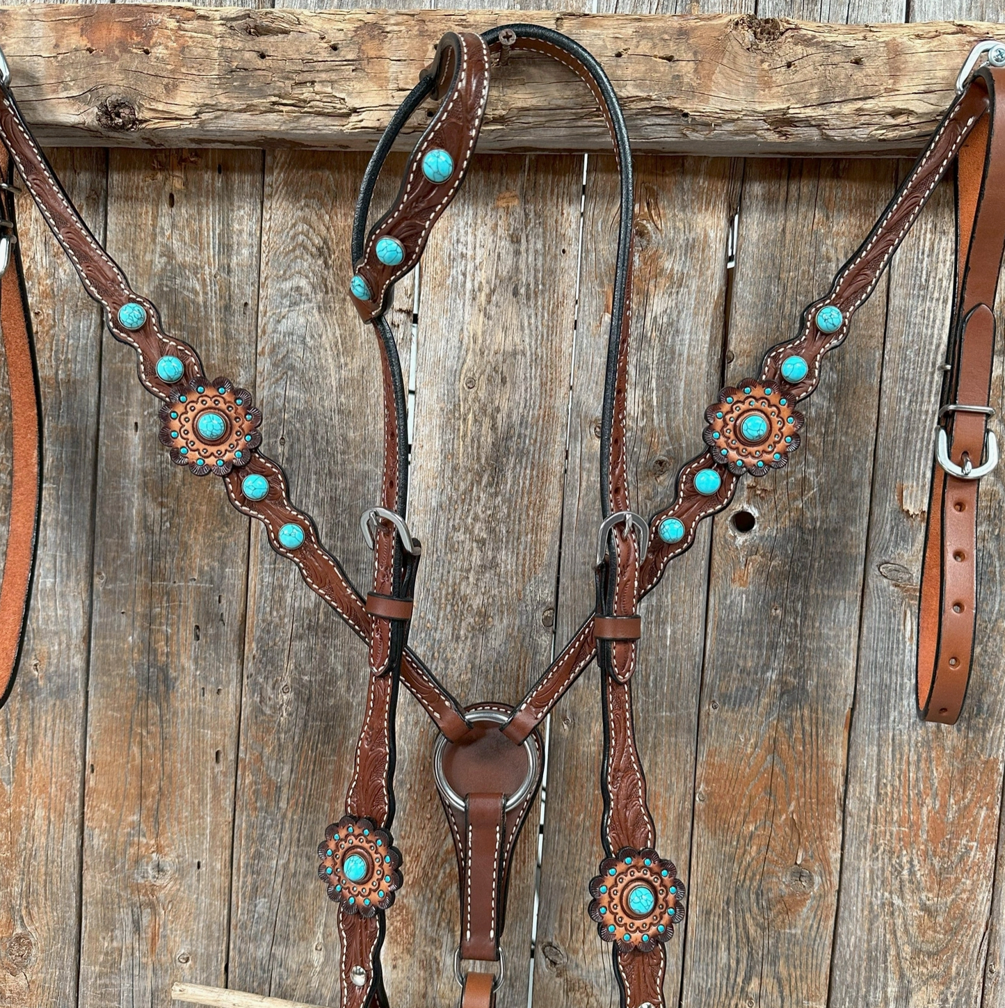 Brown leather horse bridle with turquoise stones on a wooden background