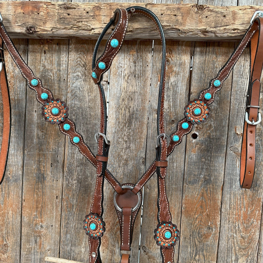 Brown leather horse bridle with turquoise stones on a wooden background