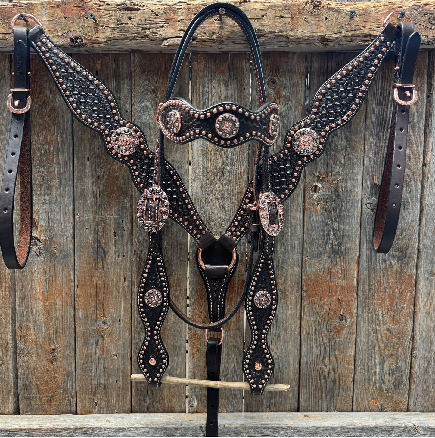 Decorative horse bridle with intricate designs on a wooden background